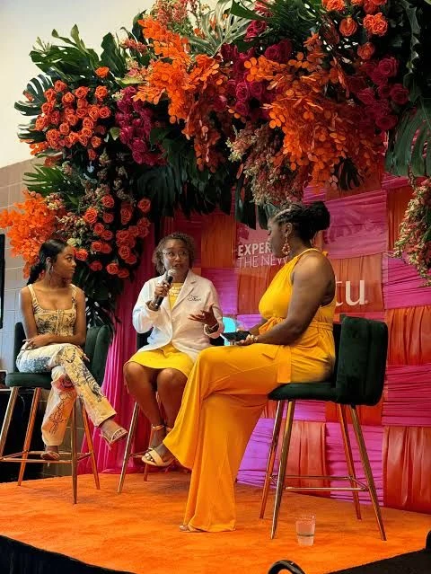 Illustrative live cultural panel framed by a vivid floral installation